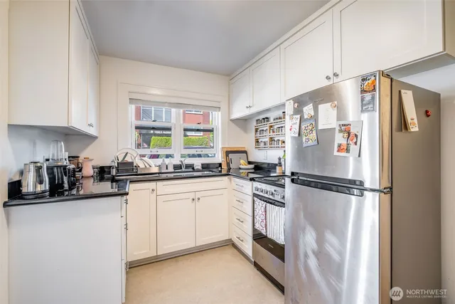 a kitchen with white cabinets and white appliances