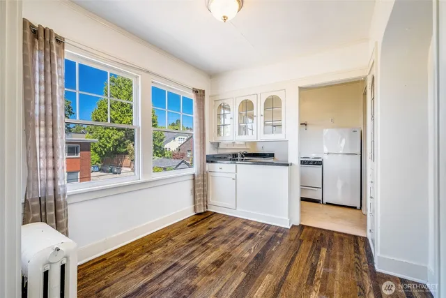 a kitchen with a refrigerator and white cabinets
