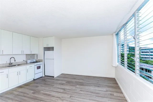 a kitchen with a sink cabinets stainless steel appliances and a window