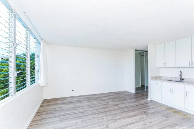 a view of a kitchen with wooden floor and a window