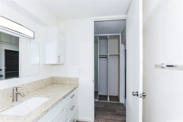 a kitchen with a granite countertop sink and white cabinets