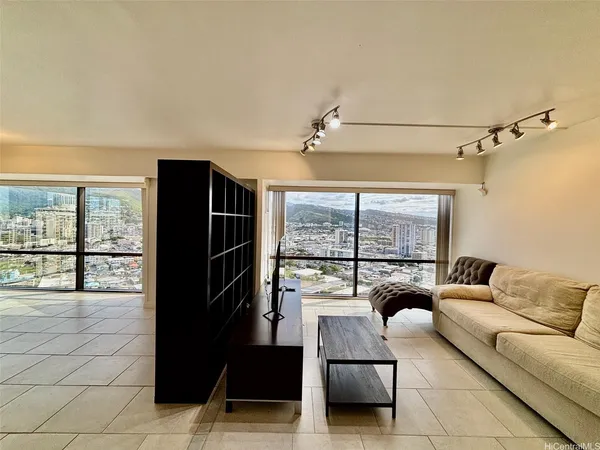 a living room with furniture a large window and stainless steel appliances
