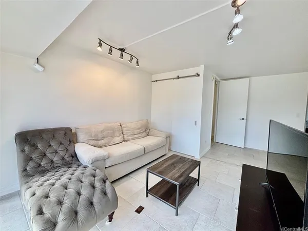 a living room with furniture and a ceiling fan