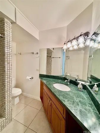 a bathroom with a granite countertop double vanity sink and a mirror