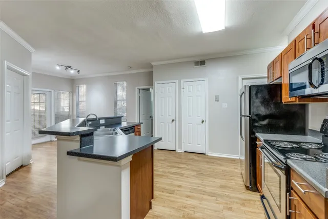 a kitchen with stainless steel appliances granite countertop a sink stove and refrigerator
