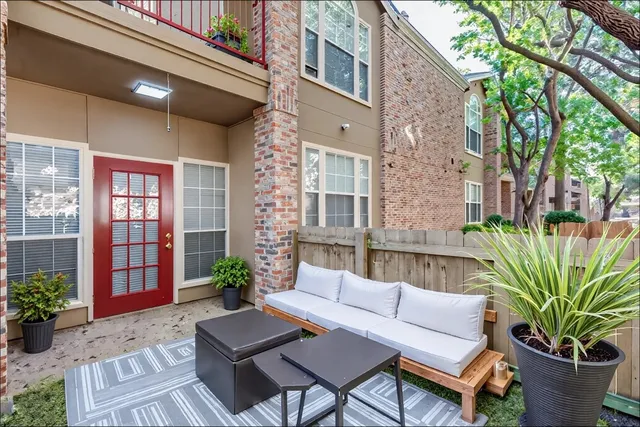 a view of a patio with couches table and chairs and potted plants