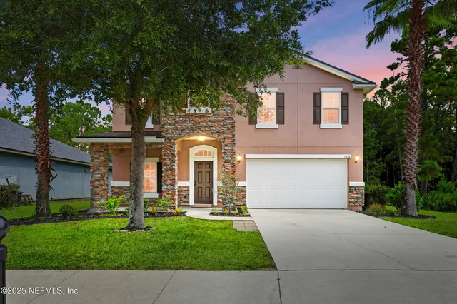 a front view of a house with a yard and garage