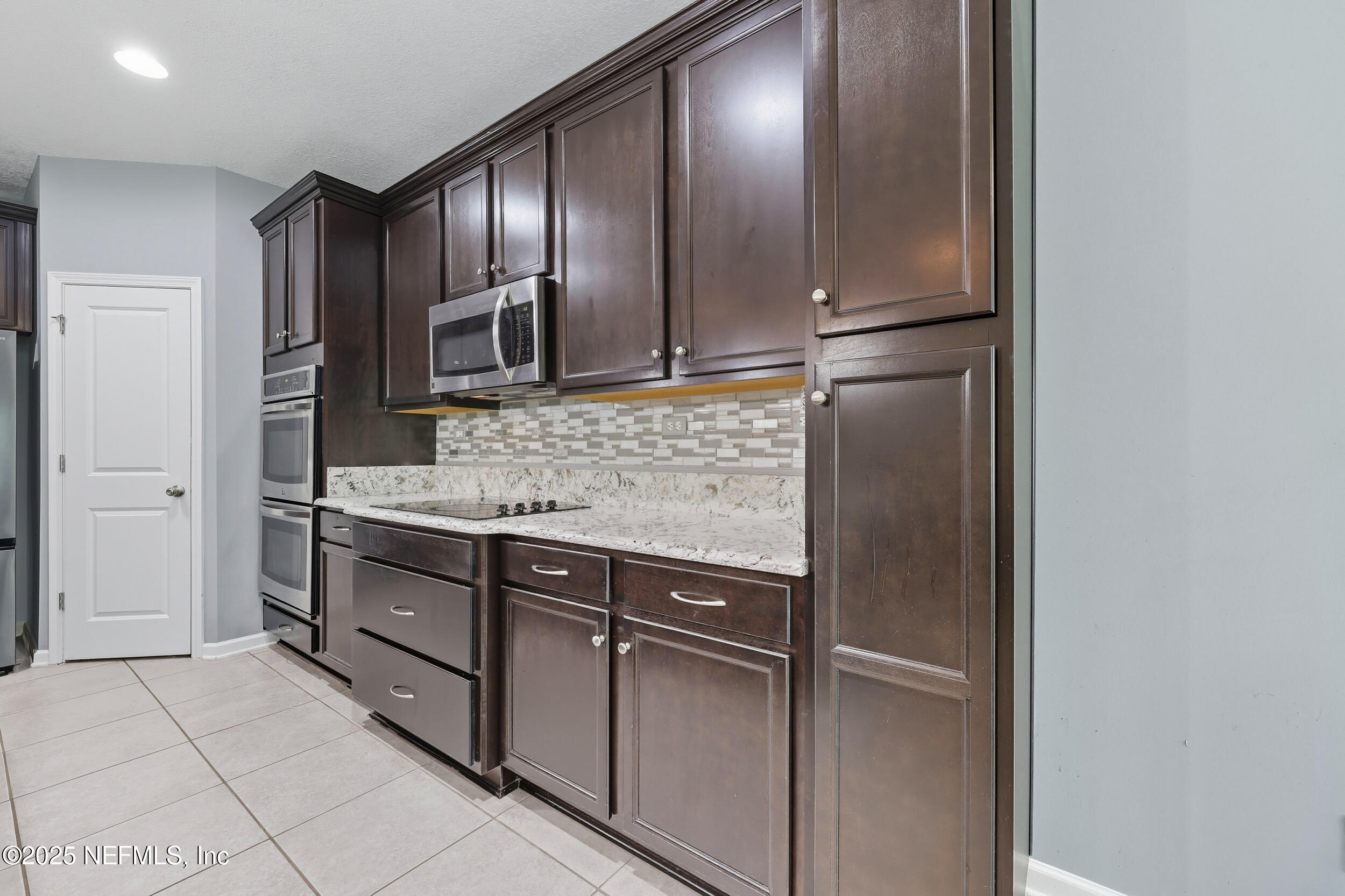 1218 Wetland Ridge Circle Middleburg, FL 32068 - Photo 24 of 75 a kitchen with stainless steel appliances granite countertop a refrigerator and a sink