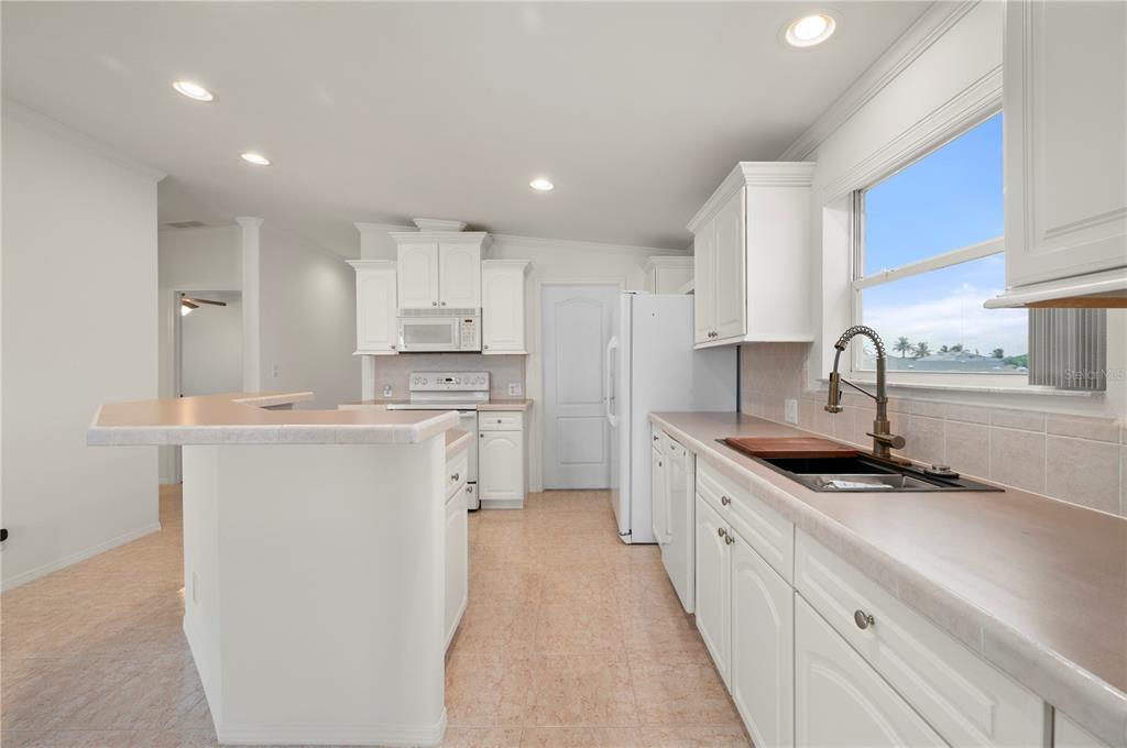67 Windmill Boulevard Punta Gorda, FL 33950 - Photo 14 of 70 a kitchen with granite countertop a sink stove cabinets and refrigerator