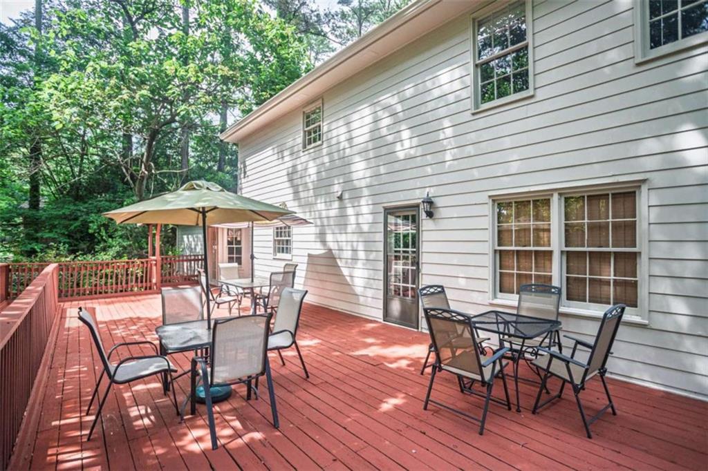 3838 Hunting Ridge Drive Southwest Lilburn, GA 30047 - Photo 50 of 56 a view of a house with table and chairs under an umbrella