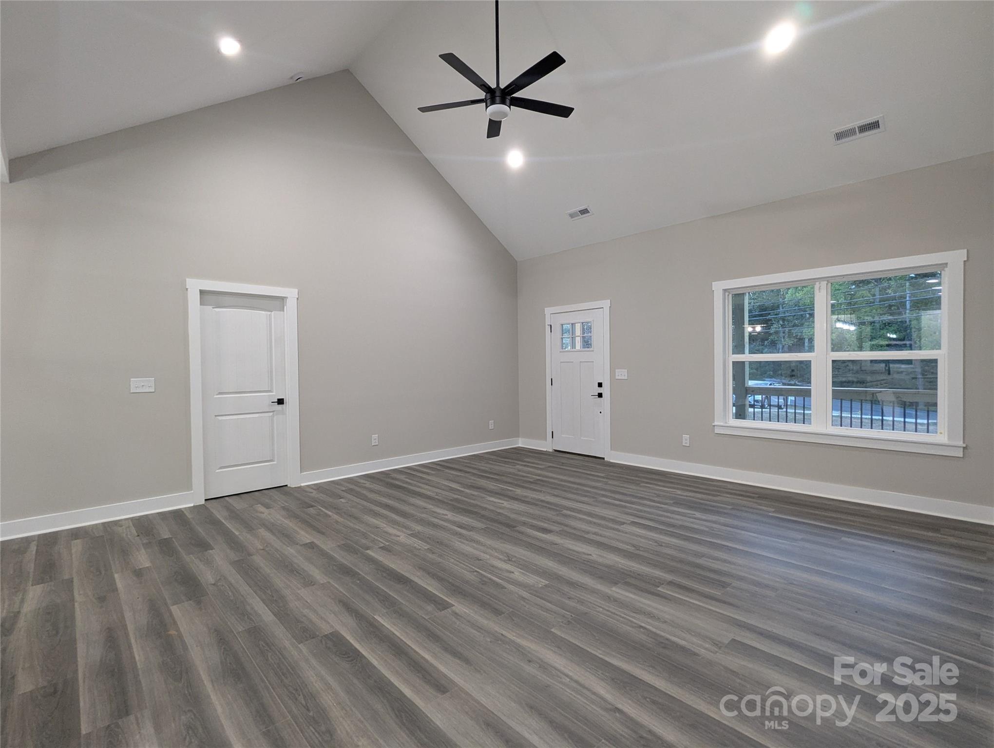 524 Waco Road Kings Mountain, NC 28086 - Photo 4 of 21 an empty room with wooden floor ceiling fan and windows