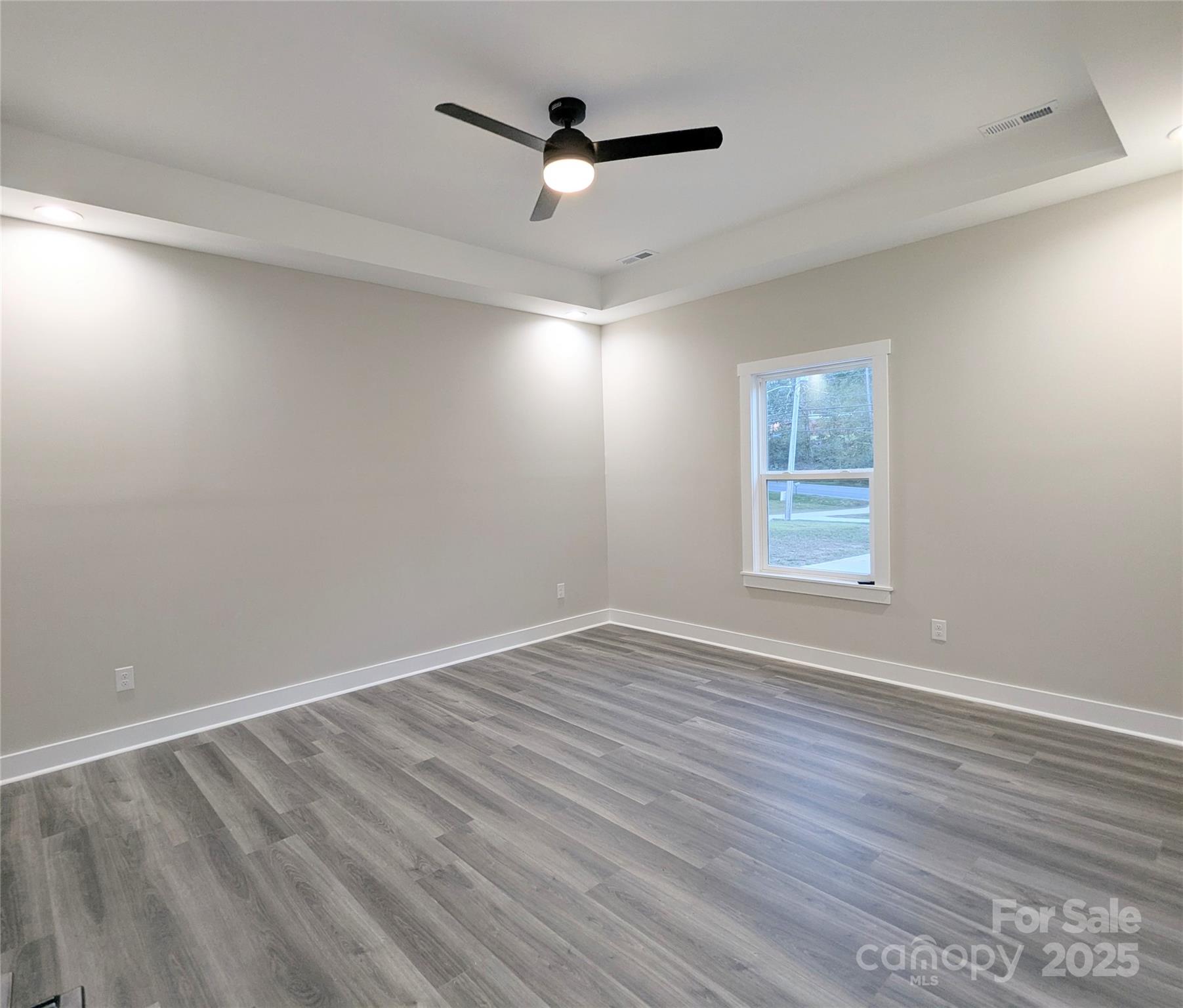 524 Waco Road Kings Mountain, NC 28086 - Photo 8 of 21 an empty room with wooden floor ceiling fan and windows