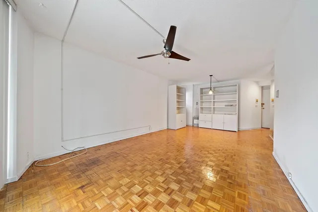a view of empty room with wooden floor