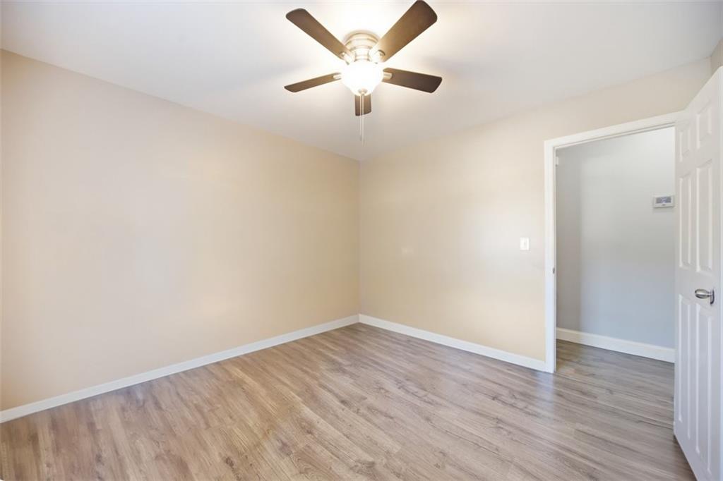 10 Stoneview Circle Covington, GA 30016 - Photo 16 of 25 an empty room with wooden floor and ceiling fan