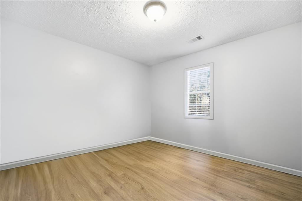 10 Stoneview Circle Covington, GA 30016 - Photo 17 of 25 an empty room with wooden floor and windows