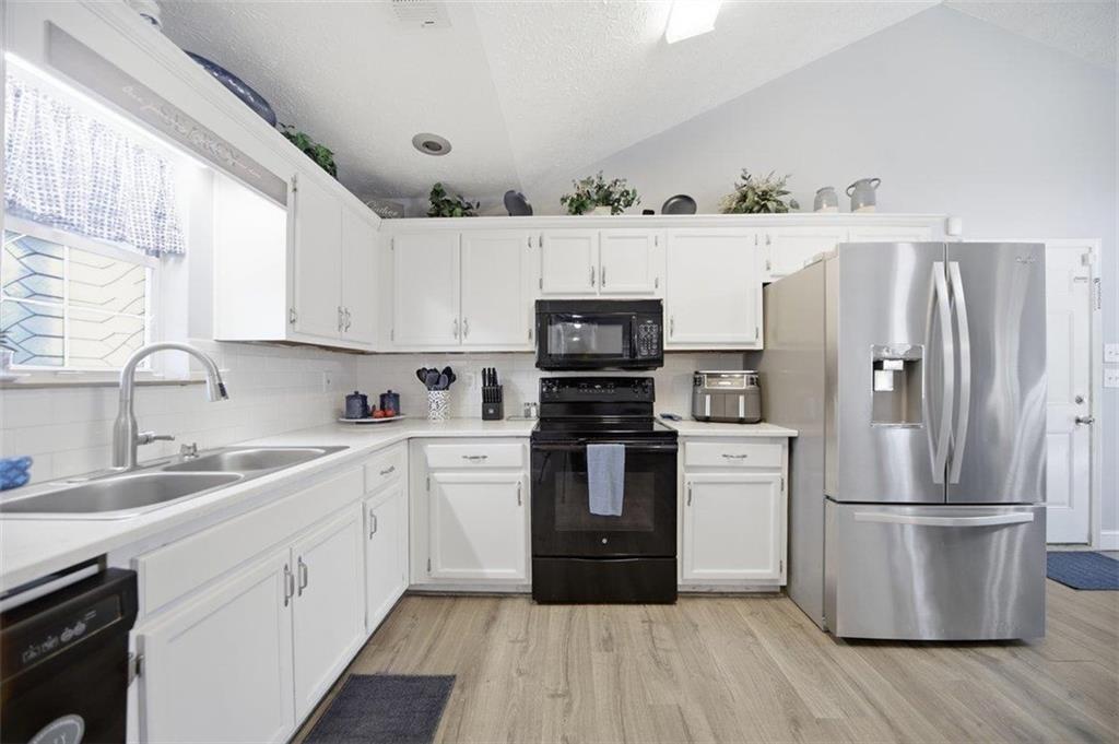 10 Stoneview Circle Covington, GA 30016 - Photo 6 of 25 a kitchen with a refrigerator cabinets and wooden floor