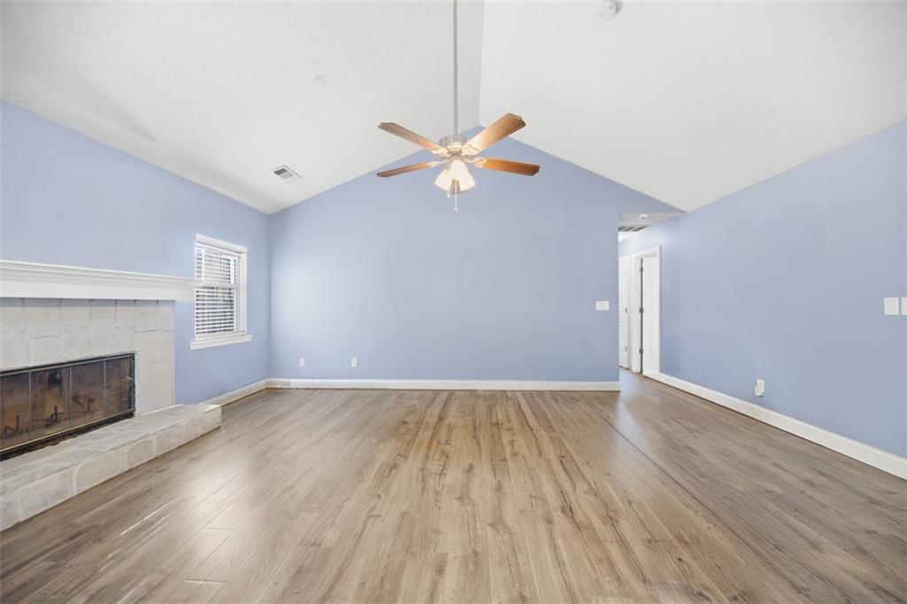10 Stoneview Circle Covington, GA 30016 - Photo 9 of 25 an empty room with wooden floor a chandelier fan and windows