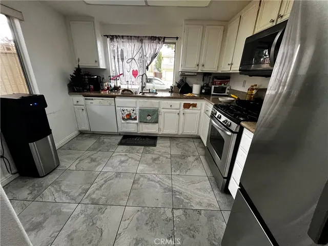 a kitchen with a sink a stove top oven a washer dryer and a window