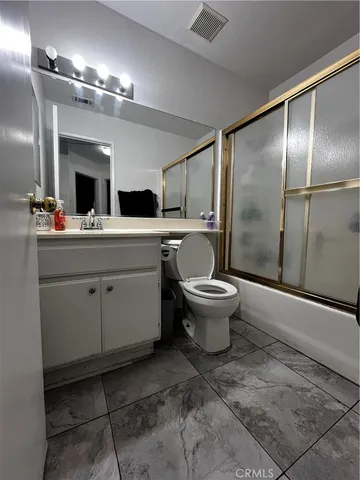 a spacious bathroom with a double vanity sink toilet and a mirror