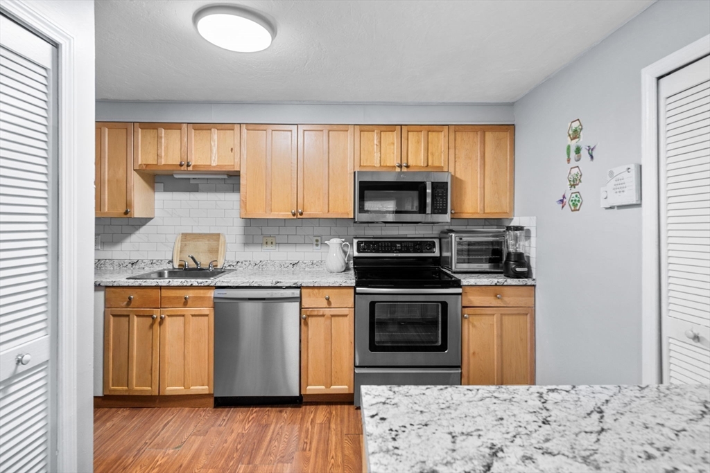 11 Gibbs Street, Unit C40 Worcester, MA 01607 - Photo 8 of 21 a kitchen with stainless steel appliances granite countertop a stove a sink and a microwave