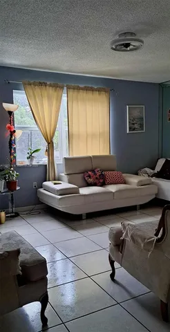 a living room with furniture and a floor to ceiling window