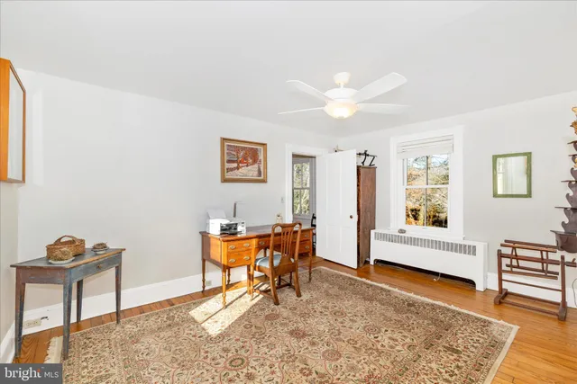a view of a hallway with entryway wooden floor and cabinet