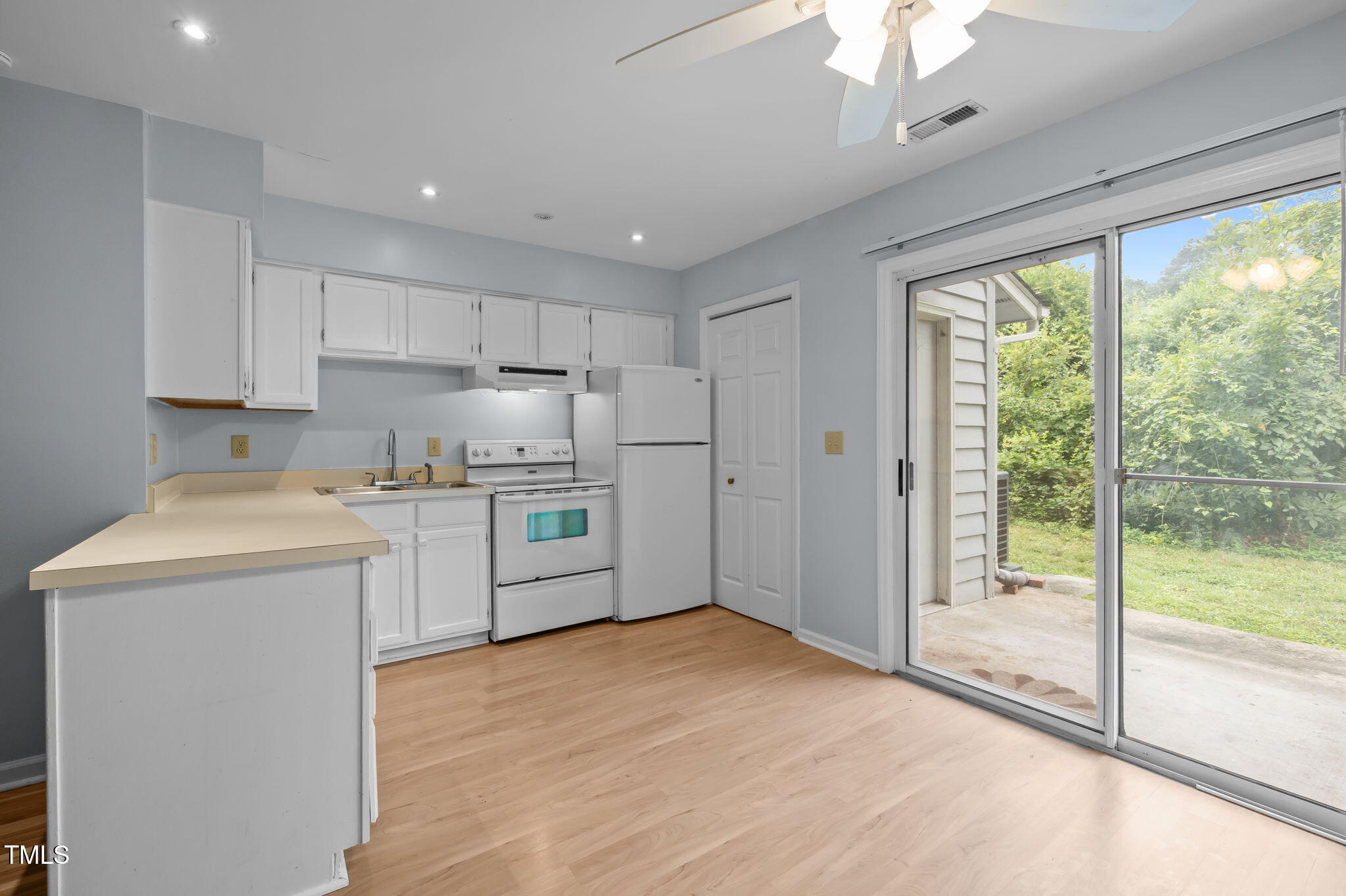 115 Coleridge Court Carrboro, NC 27510 - Photo 10 of 33 a kitchen with a refrigerator a stove top oven and white cabinets next to a window