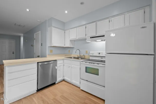 a kitchen with white cabinets and white appliances