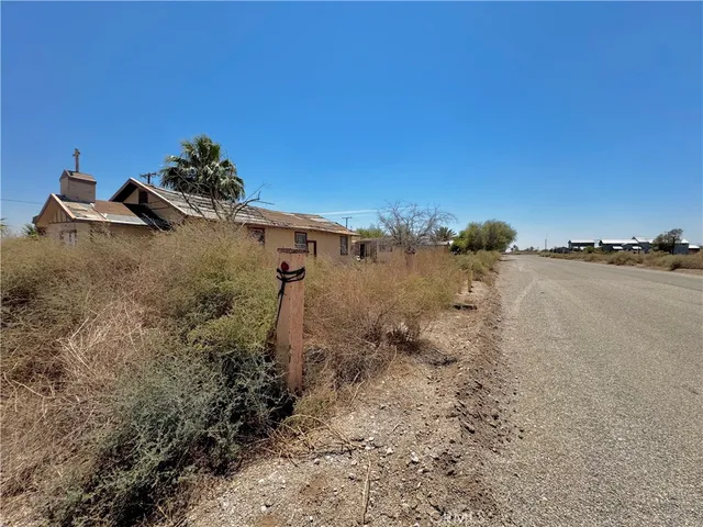a view of a dry yard with wooden fence