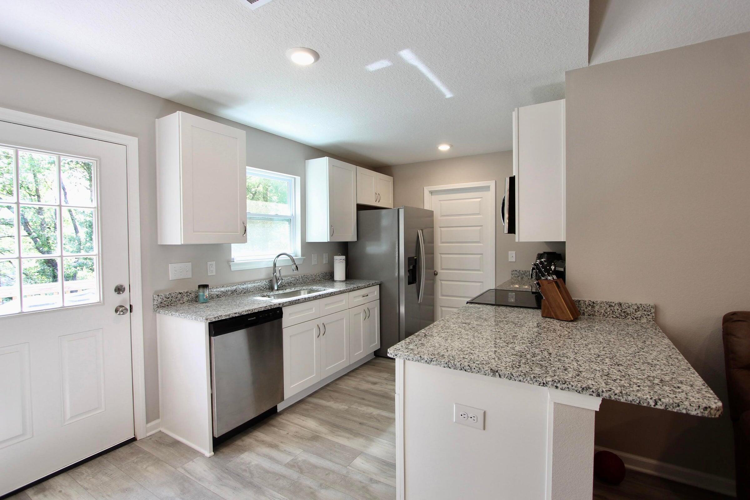 102 Windsor Drive Crestview, FL 32539 - Photo 12 of 25 a kitchen with stainless steel appliances granite countertop a sink stove and refrigerator