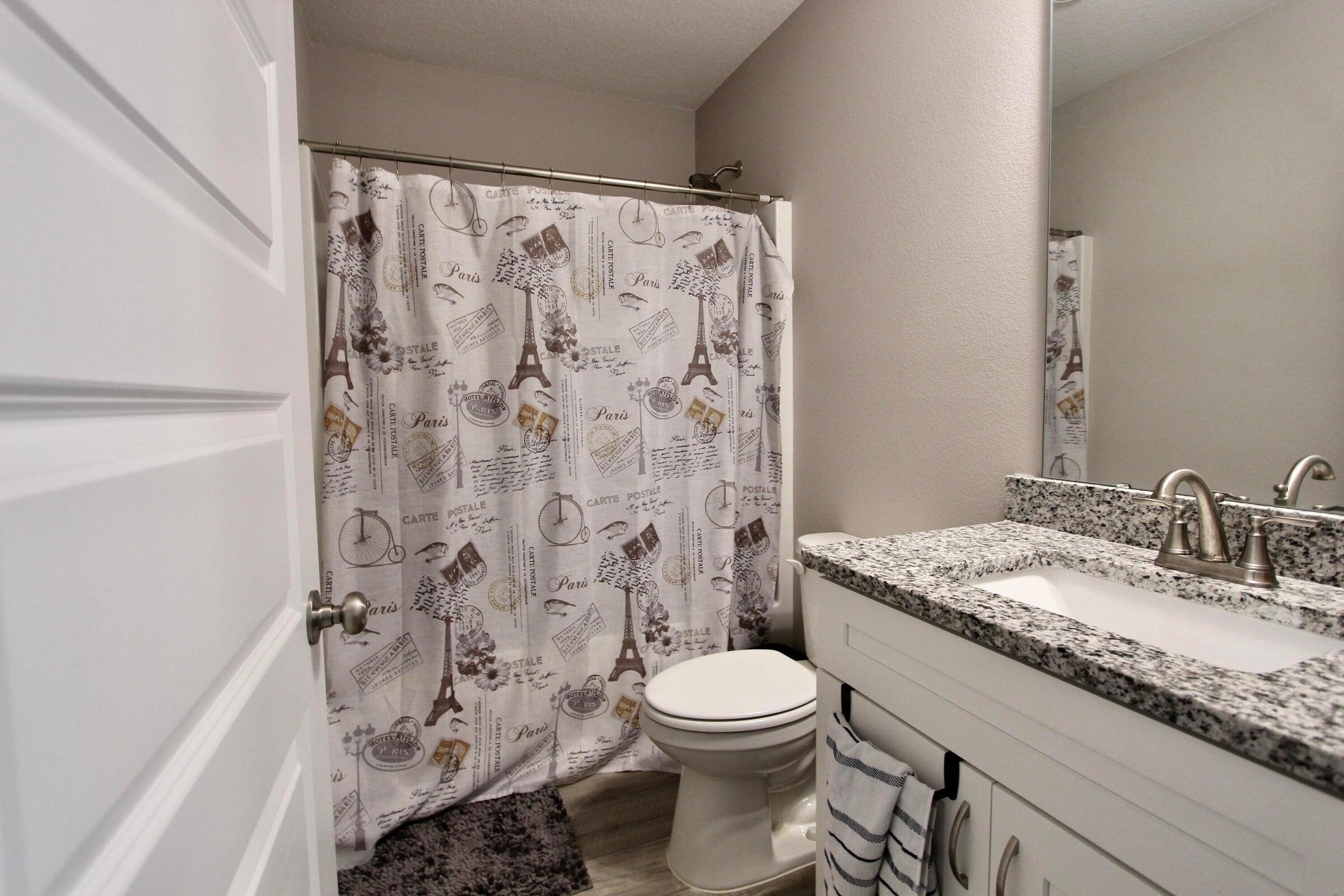 102 Windsor Drive Crestview, FL 32539 - Photo 15 of 25 a bathroom with a granite countertop toilet a sink and a shower