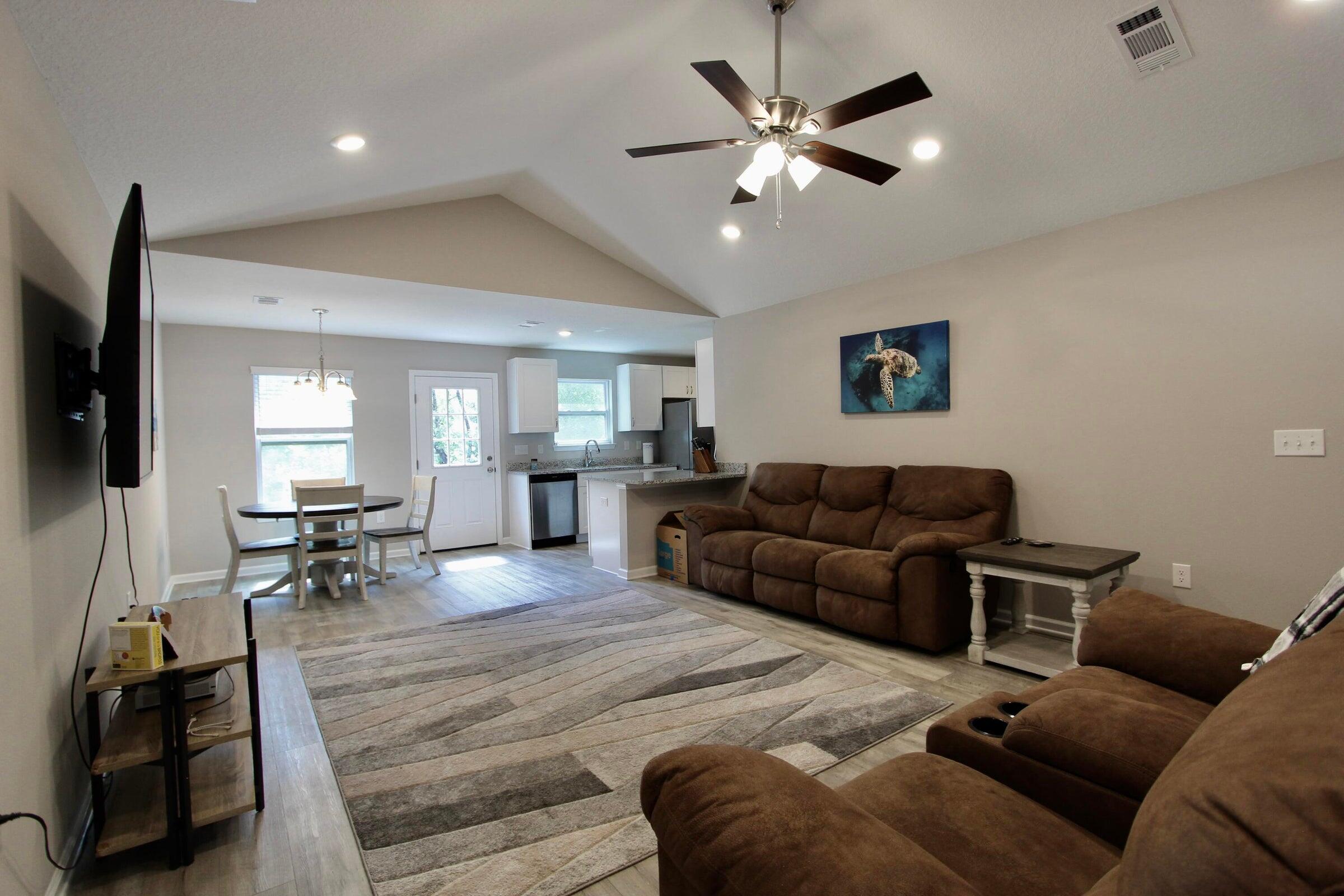 102 Windsor Drive Crestview, FL 32539 - Photo 5 of 25 a living room with furniture and a flat screen tv with kitchen view