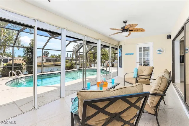 a dining room with furniture water view and a floor to ceiling window