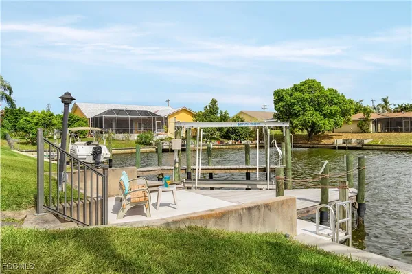 a view of a lake with a bench and large trees