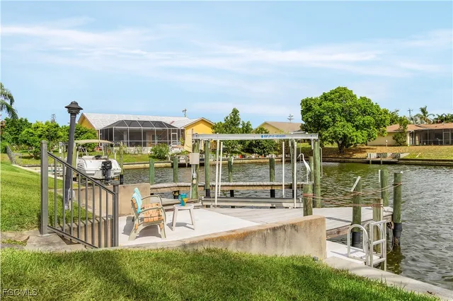 a view of a lake with a bench and large trees