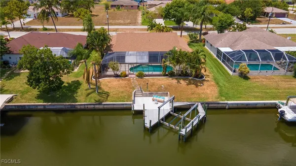 an aerial view of a house with a garden and lake view