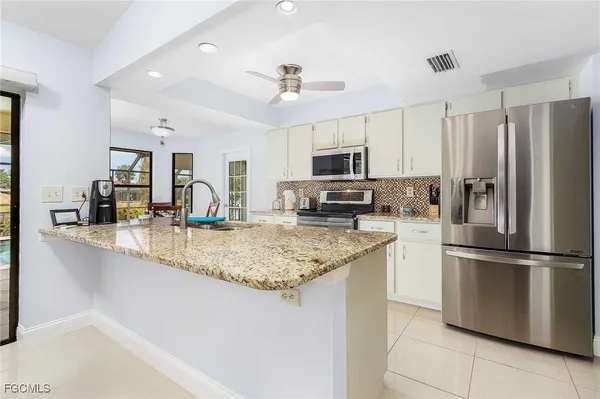 a kitchen with stainless steel appliances granite countertop a sink refrigerator and microwave