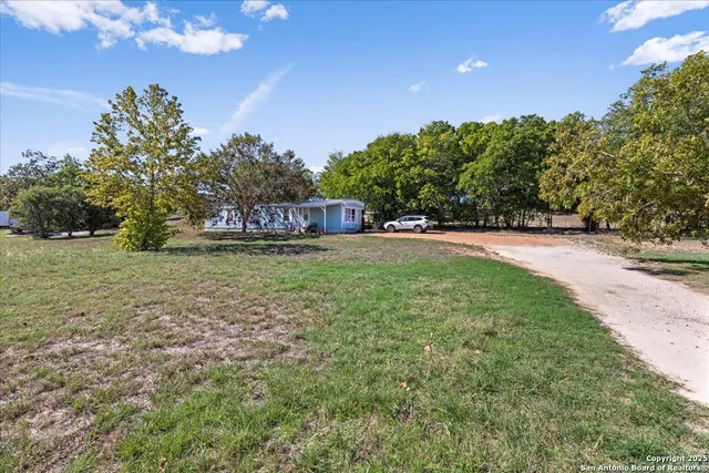 a view of a field with trees in the background