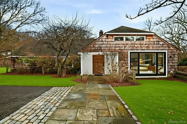 a front view of a house with a yard and trees