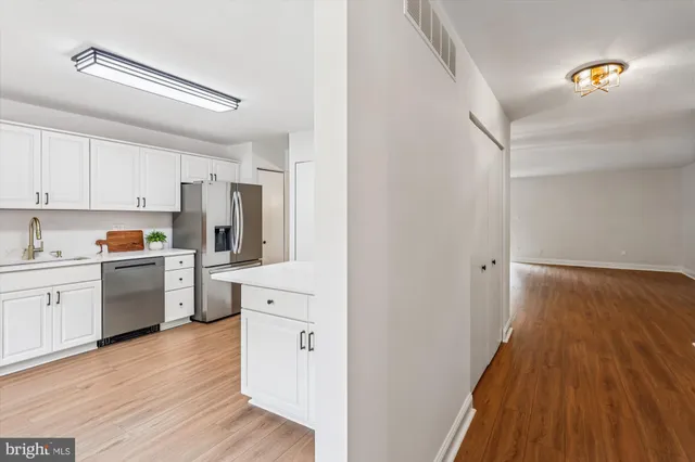 a kitchen with stainless steel appliances white cabinets and a stove top oven