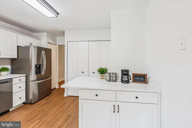 a view of a room with wooden floor chandelier and windows