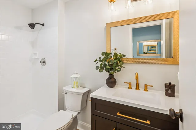a view of an empty room with chandelier fan and fire place