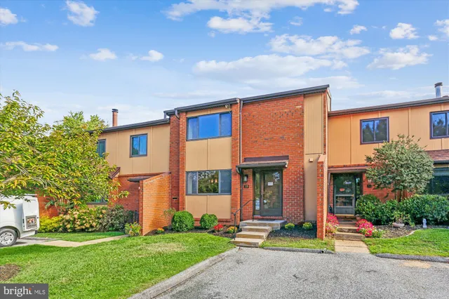 a front view of a house with a yard and potted plants