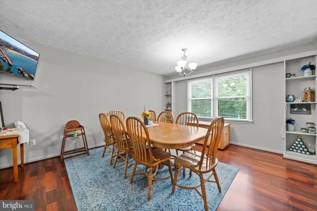 a dining room with furniture a chandelier and wooden floor