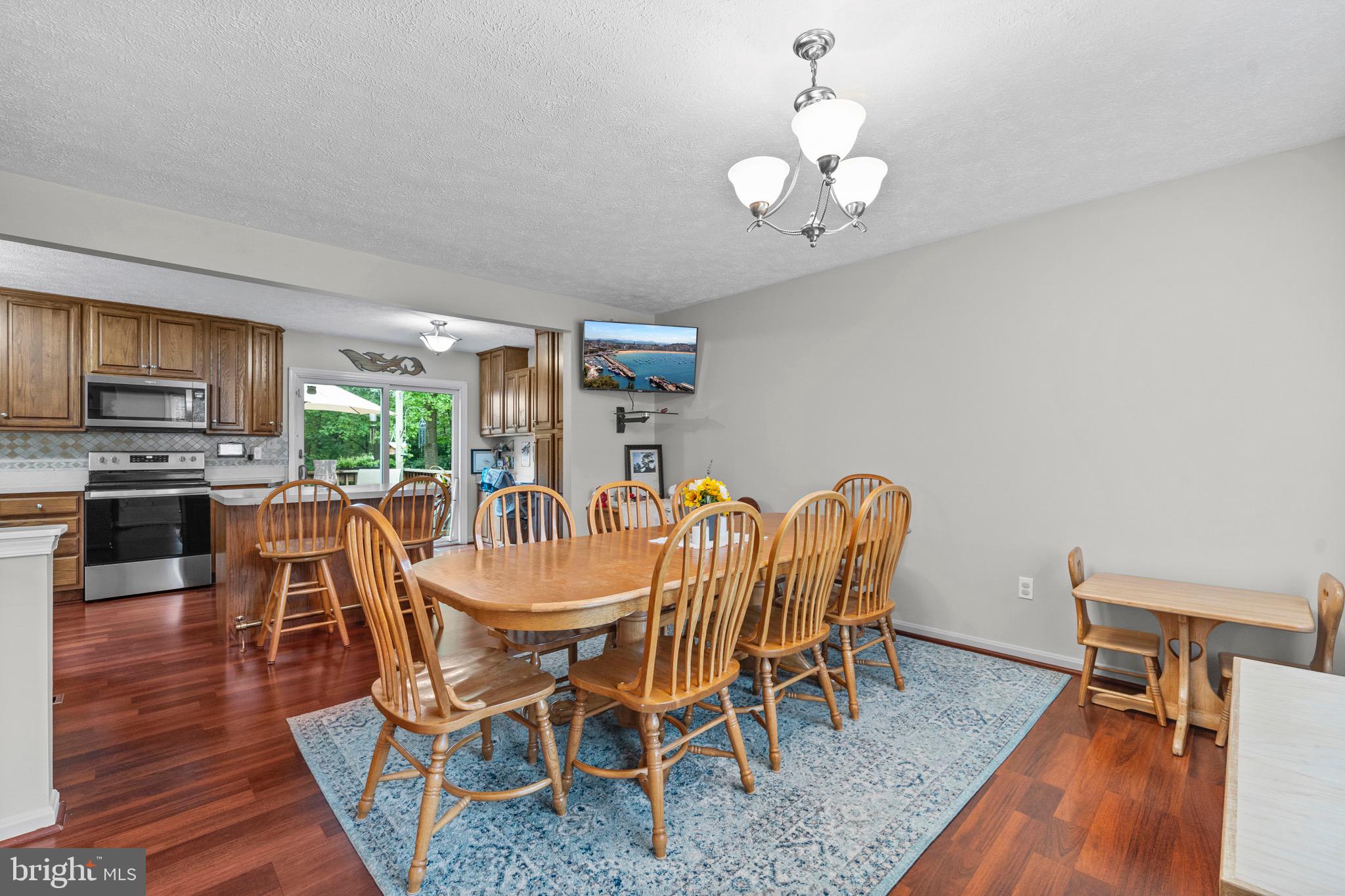 26599 Yowaiski Mill Road Mechanicsville, MD 20659 - Photo 16 of 58 a dining room with furniture a chandelier and wooden floor