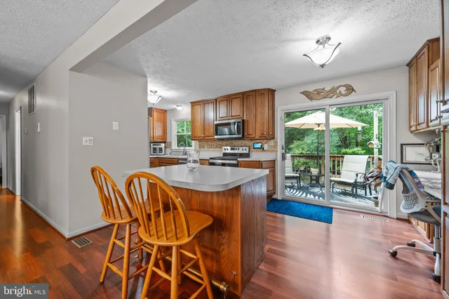 a kitchen with stainless steel appliances granite countertop sink stove and wooden floor