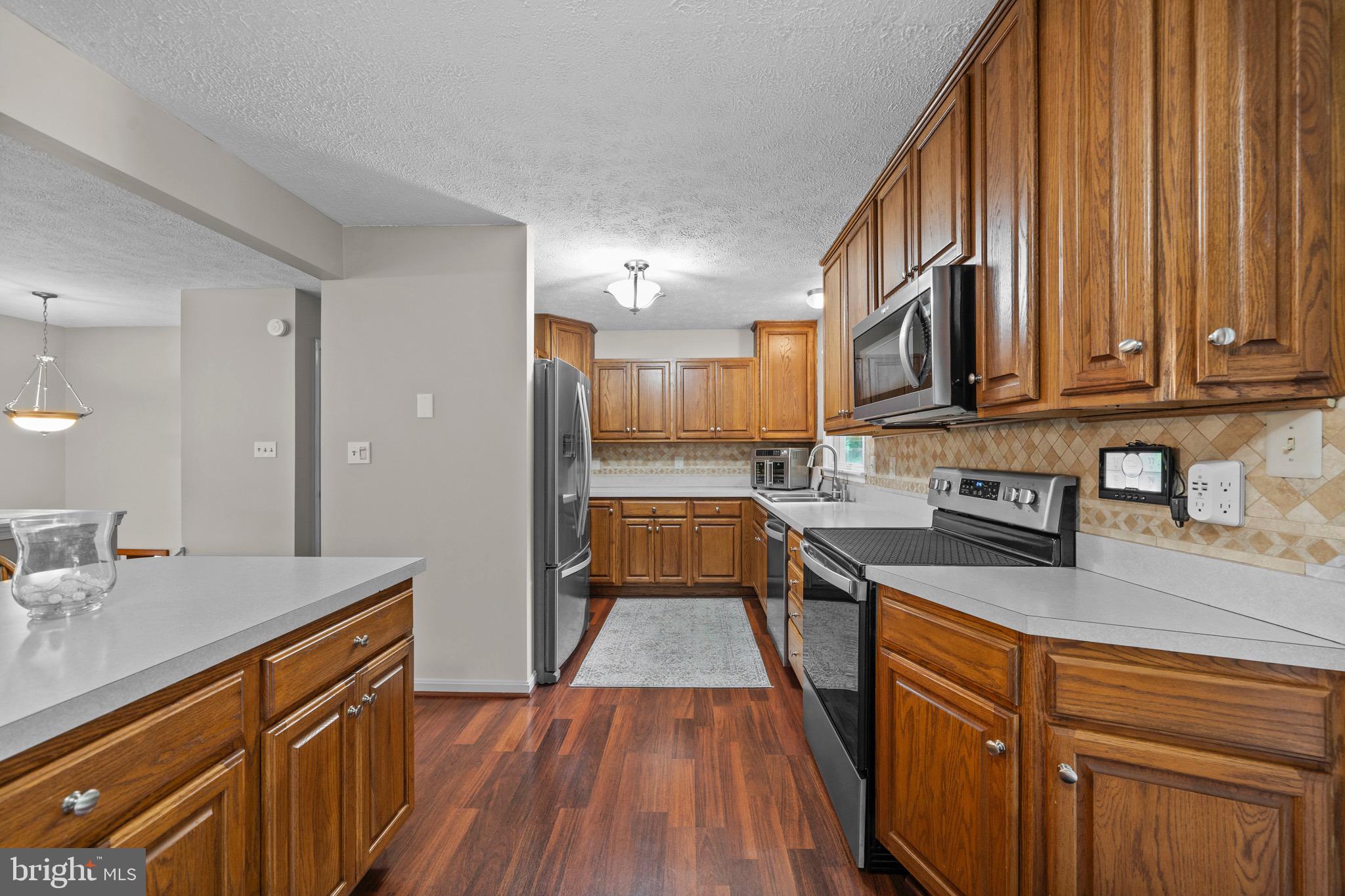26599 Yowaiski Mill Road Mechanicsville, MD 20659 - Photo 20 of 58 a kitchen with stainless steel appliances granite countertop a stove a sink dishwasher and a microwave oven with wooden floor