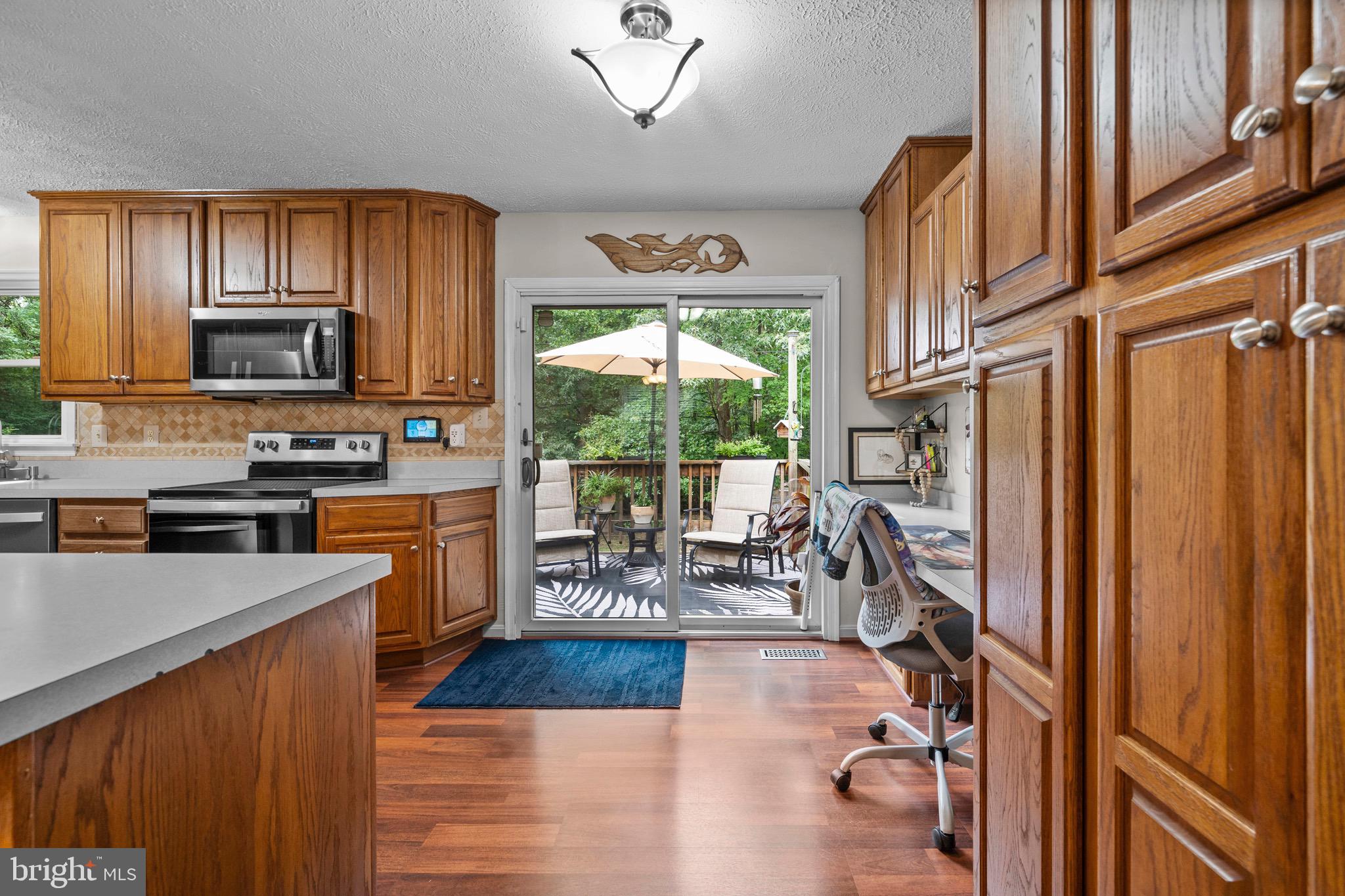 26599 Yowaiski Mill Road Mechanicsville, MD 20659 - Photo 25 of 58 a kitchen with stainless steel appliances granite countertop sink stove top oven and cabinets
