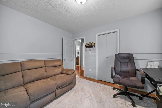 a bedroom with a bed and flat tv screen on the dresser