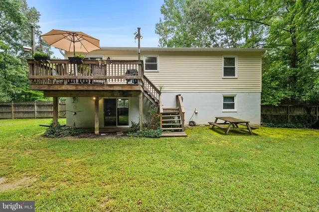 a view of a house with a backyard and a tree